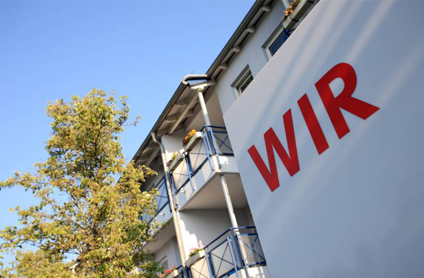 WIR Schriftzug mit Wohnungen.